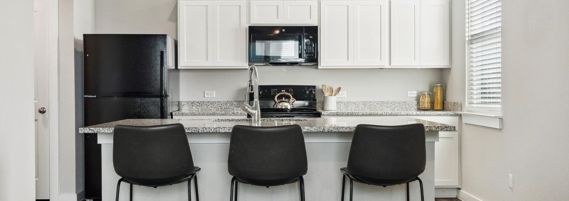 a kitchen with black chairs and white cabinets at The  Powell